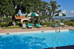 斯卡利諾的住宿－Casa Vacanze Bicchi，一个带两把遮阳伞和椅子及一张桌子的游泳池