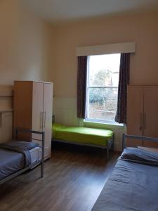 a room with two beds and a window at Belsize House (Belsize Park) in London