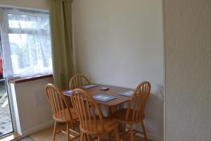 een eettafel met 4 stoelen en een raam bij Huccaby Tor Apartmernt in Torquay