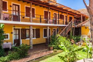 ein gelbes Haus mit einer Treppe davor in der Unterkunft Tico Tico Apart in Mina Clavero