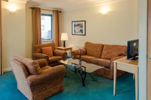 a living room with a couch and two chairs and a tv at DCU Rooms Glasnevin - Campus Accommodation in Dublin