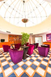 a library with purple chairs and a glass ceiling at Don Giovanni Hotel Prague - Great Hotels of The World in Prague