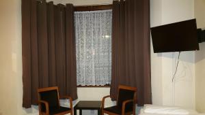 a room with a window with chairs and a table at Best Inn Hotel in Ilford