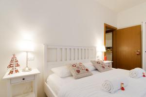 una camera da letto con un letto bianco e un albero di Natale sopra di B&B and Apartments Al Duomo a Trento