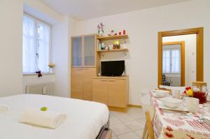 una camera con letto, TV e tavolo di B&B and Apartments Al Duomo a Trento