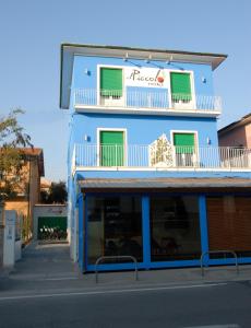 a blue building with a balcony on a street at Il Piccolo Rooms in Pontedera