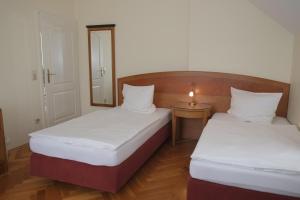 2 Betten in einem kleinen Zimmer mit Spiegel in der Unterkunft Gästewohnung Elström in Dresden