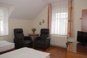 ein Wohnzimmer mit 2 Stühlen und einem TV in der Unterkunft Gästewohnung Elström in Dresden