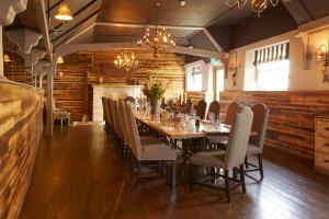 uma sala de jantar com uma mesa longa e cadeiras em The Bull Hotel em Fairford