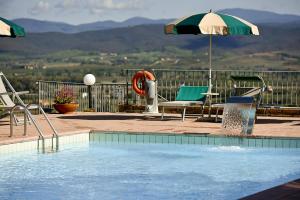 piscina con sedie e ombrellone di Casa Vacanze Bicchi a Scarlino