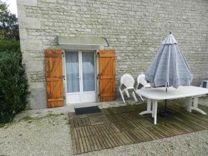 een tafel en stoelen en een parasol op een patio bij la maison du parc in Dammarie-sur-Saulx