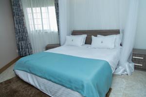 Postel nebo postele na pokoji v ubytování Villa Karibu Serviced Apartments-Kampala