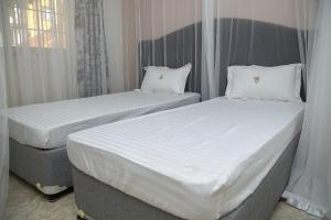 Postel nebo postele na pokoji v ubytování Villa Karibu Serviced Apartments-Kampala