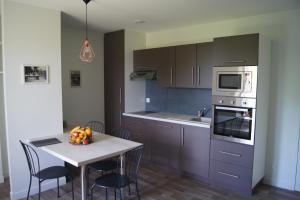 a kitchen with a table with a bowl of fruit on it at Les Gîtes de l’Oree in Bécherel