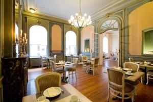 um restaurante com mesas, cadeiras e janelas em Charme Hotel Hancelot em Gent