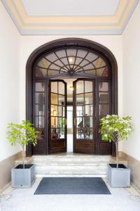 an open door with two potted trees in front of it at Charme Hotel Hancelot in Ghent