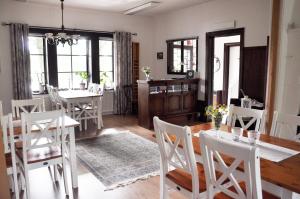 une salle à manger avec des chaises blanches et une table dans l'établissement Sköna Rum Fryksta, à Kil