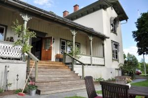 une maison avec une terrasse couverte et des escaliers en face de celle-ci dans l'établissement Sköna Rum Fryksta, à Kil