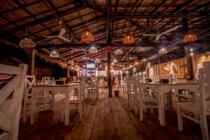 a dining room with white tables and chairs at Sara Resort in Koh Rong Sanloem