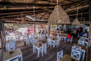 a restaurant with white chairs and tables and a bar at Sara Resort in Koh Rong Sanloem