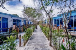a walkway leading to a row of blue buildings at Sara Resort in Koh Rong Sanloem