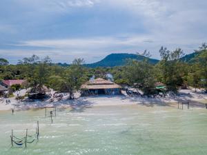 a beach with a hut in the middle of the water at Sara Resort in Koh Rong Sanloem