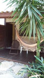 a hammock on the porch of a house at Pousada Lugar Comum in Boicucanga