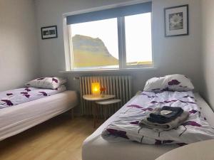 um quarto com 2 camas, uma janela e uma mesa em Guesthouse 43 em Grundarfjordur