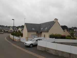 a car parked in a parking lot next to a house at La Roseraie in Ergué-Gabéric