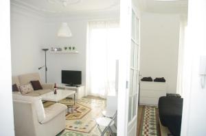 a white living room with a couch and a tv at Carlos & Ana Amplio Apartamento 4 Habitaciones Centro Valencia in Valencia
