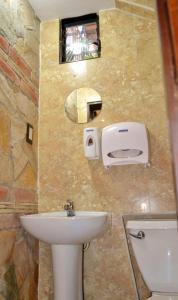 bagno con lavandino, servizi igienici e specchio di Hotel Villa Florencia Centro Histórico a San Salvador