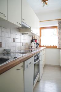 cocina blanca con electrodomésticos blancos y ventana en Haus Arnold Schranz, en Sankt Anton am Arlberg