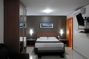 a bedroom with a bed and a flat screen tv at Bristol Evidence Hotel in Goiânia