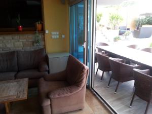 a room with chairs and a table and a table and a glass door at Apartment Nella Kostrena in Kostrena +32 photos