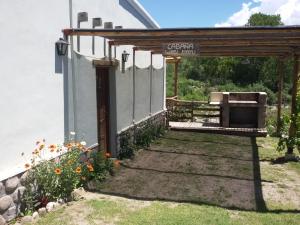 uma pérgola com uma grelha num quintal em Cabañas Wasi Mayu em Tafí del Valle