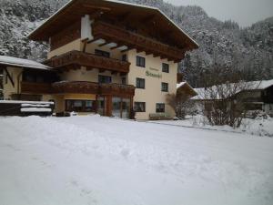 ein großes Gebäude mit Schnee davor in der Unterkunft Haus Weidmannsheil in Längenfeld
