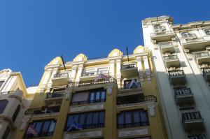 a tall yellow building with balconies and a blue sky at Carlos & Ana Amplio Apartamento 4 Habitaciones Centro Valencia in Valencia