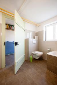 a bathroom with a toilet and a tub and a sink at Bed&Breakfast Pinocchio in Seuzach