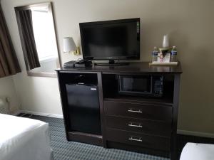 a television on a dresser in a hotel room at Mainstay Inn in Phoenixville