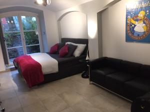 a bedroom with a bed and a couch and a window at Schlosspark Residenz in Schwerin