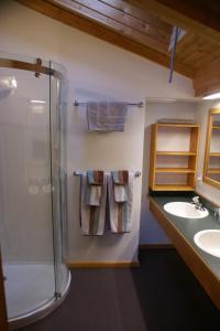 a bathroom with a shower and two sinks and towels at Alpenglow Bed and Breakfast in Kimberley +68 photos