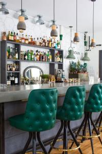 a bar with green leather bar stools at Main and Mountain in Ludlow