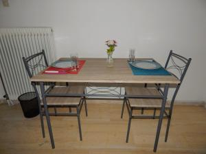 a wooden table with two chairs and a vase of flowers at Cozy apartment for 2-5 people-Center Tripoli in Tripoli