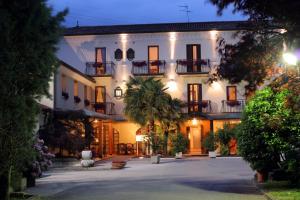 a large white house with a courtyard at night at Hotel Antico Mulino in Scorzè