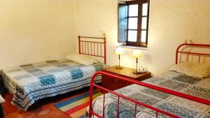 a bedroom with two beds and a window at Monte do Altinho in Tanganheira