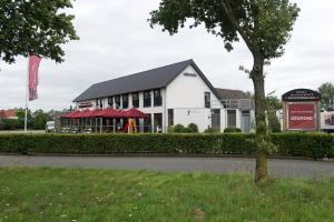 un gran edificio blanco con una señal roja delante de él en Hotel Restaurant Keizersberg, en Elsendorp