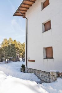 a white building with snow on the ground at Chesa San Gian - Celerina in Celerina