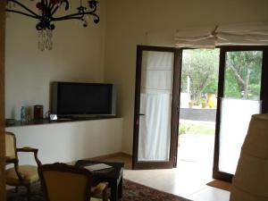 a living room with a tv and a sliding glass door at Bo Hotel De Encanto & Spa in Chicoana