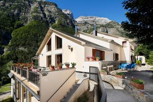 a house with flowers on a balcony with mountains in the background at Camping Pineta in Bielsa