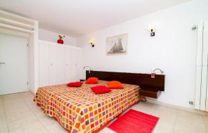 a bedroom with a bed with red pillows on it at Excellent Golden Apartment in Cabanas de Tavira +23 photos